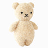 The Cuddle + Kind Baby Bouclé Bear - Honey is a soft, light brown plush teddy bear with small black eyes, a black nose, and a simple stitched mouth, standing upright against a plain white background.