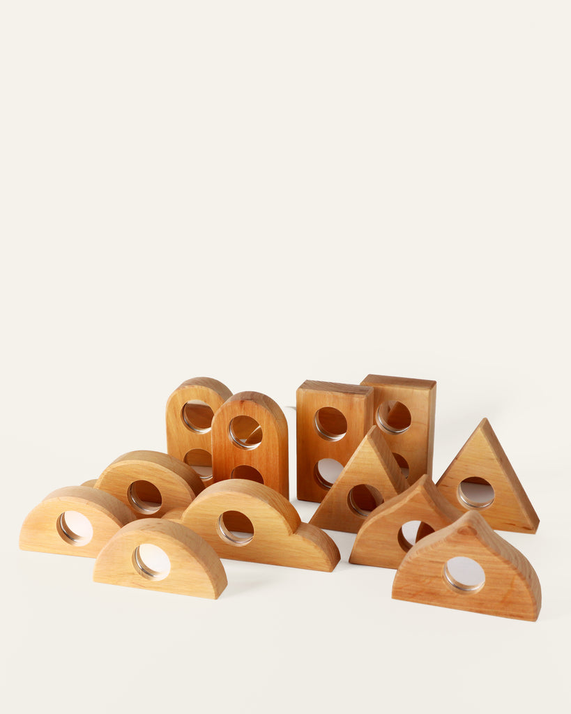 A set of twelve Bauspiel Mirror Blocks, 12-Piece Set, featuring wooden building blocks in various shapes each with a circular mirror insert.
