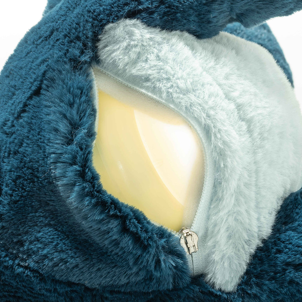 A close-up of the Steiff Light at Night Spott Stegosaurus Stuffed Plush, 11 Inches, shows its blue and white fur with a partially open zipper revealing a smooth yellow plastic interior beneath the fabric.