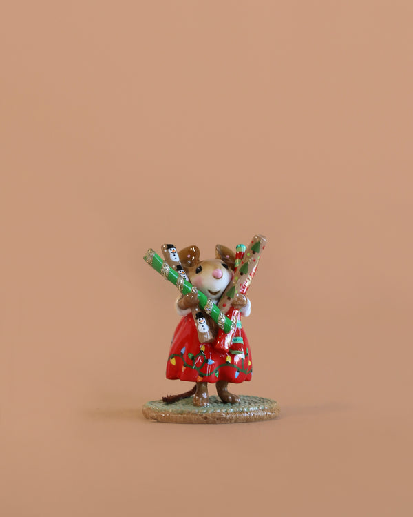 The Wee Forest Folk Tiny Collectible - Wrap it Up! features a hand-sculpted mouse in a red dress with holiday crackers, standing on a round base—an adorable miniature for collectors.