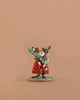 The Wee Forest Folk Tiny Collectible - Wrap it Up! features a hand-sculpted mouse in a red dress with holiday crackers, standing on a round base—an adorable miniature for collectors.
