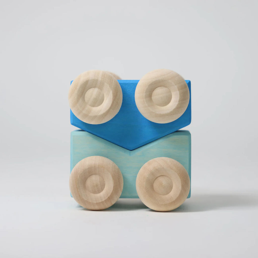 Two stacked Grimm's Stacking Cars - Blue feature a light blue car and a chevron-shaped bright blue car, each with two round, light wood wheels, displayed on a plain white background.