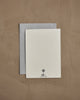 The Coral & Tusk Fox Mama Card—a white textured keepsake with a small tree logo and "CORAL & TUSK" at the bottom—comes atop a gray envelope on a light brown surface, making it an ideal gift for new parents.