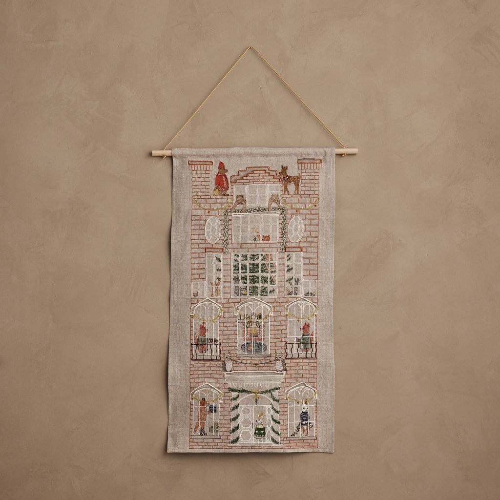 Coral & Tusk Holiday House Advent Calendar wall hanging featuring an embroidered illustration of a multi-story home with twenty-four small pockets across windows and balconies.