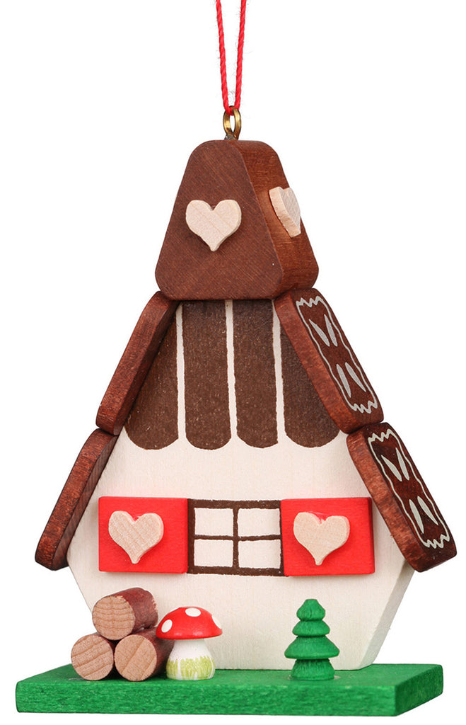 Christian Ulbricht Ornament - Gingerbread House made in Germany, featuring red heart shutters, a mushroom, a stack of logs, and a small green tree on a green base. Warning: contains small parts.