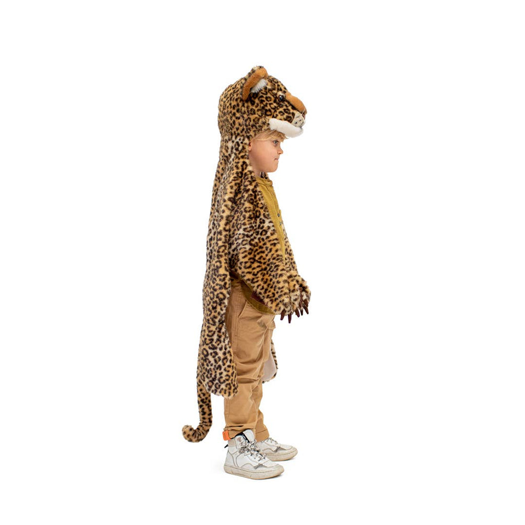 A young child stands in profile wearing the Costume - Leopard, which features a faux fur design with a hood, tail, and paw-like gloves. The background is plain white.