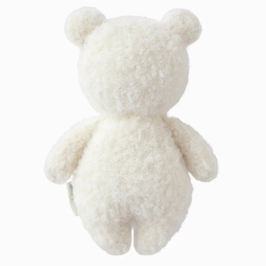 The Cuddle + Kind Baby Bouclé Bear in Ivory is a plush toy hand-knit from soft Peruvian alpaca yarn, shown from the back with round ears and no visible facial features on a plain white background.
