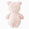 The Cuddle + Kind Baby Bouclé Bear - Strawberry is a soft, fluffy, light pink teddy bear made from Peruvian alpaca yarn. Shown from the back on a white background, it features round ears, short arms and legs, and no visible facial features.