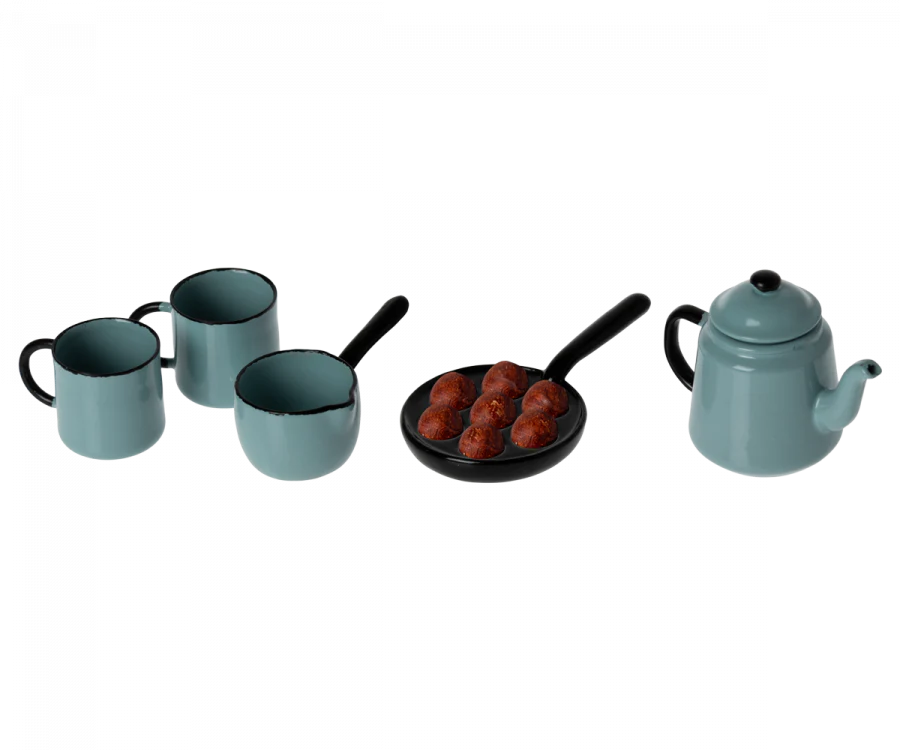 A Maileg Blue Kitchen Set featuring two blue mugs, a blue pitcher, a blue teapot, and a black skillet containing six small brown meatballs.