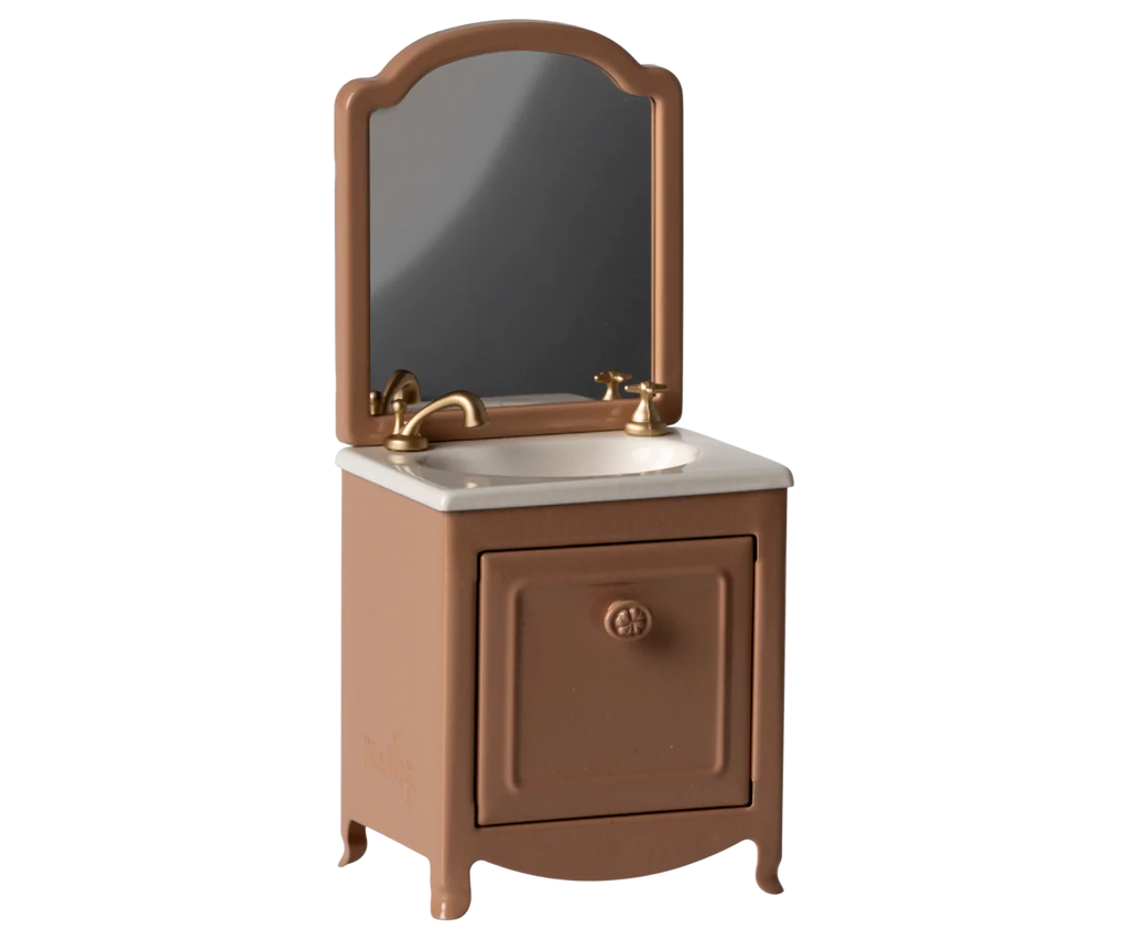 The Maileg Sink Dresser With Mirror, Mouse - Dark Powder features a miniature brown vanity with a white sink, gold faucet, and rectangular mirror—ideal vintage-style dollhouse bathroom furniture for your mouse house.