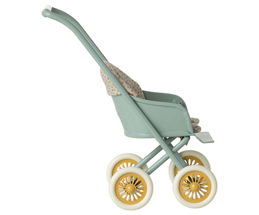 Side view of the Maileg Stroller, Micro - Mint featuring a vintage design with a green frame, yellow wheels, and a patterned seat. The empty stroller is set against a light striped background.