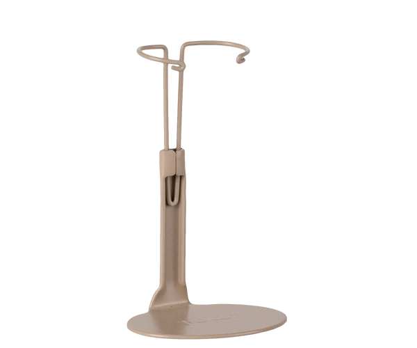 The Maileg Mouse Stand, Small - Sand is a beige minimalist stand with a circular base and upper loop to hold items upright, shown on a plain white background. Ideal for displaying your mice collection.