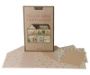 A Maileg Farmhouse Dollhouse with Wallpaper box standing behind several sheets of patterned wallpaper stickers.