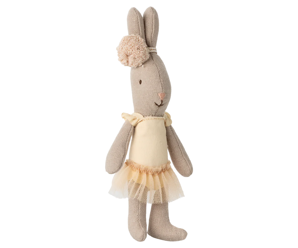 A soft Maileg Rabbit, Micro in cream, dressed in a ballet suit and skirt, stands upright against a neutral striped background.