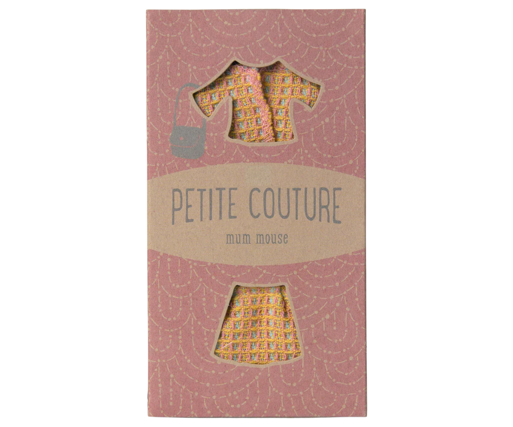 The "Maileg Suit For Mum Mouse" package showcases a chic ensemble with a yellow floral dress, matching jacket, and skirt set. The attire is displayed against a pink background featuring a subtle wave pattern that elegantly frames the cutout sections.