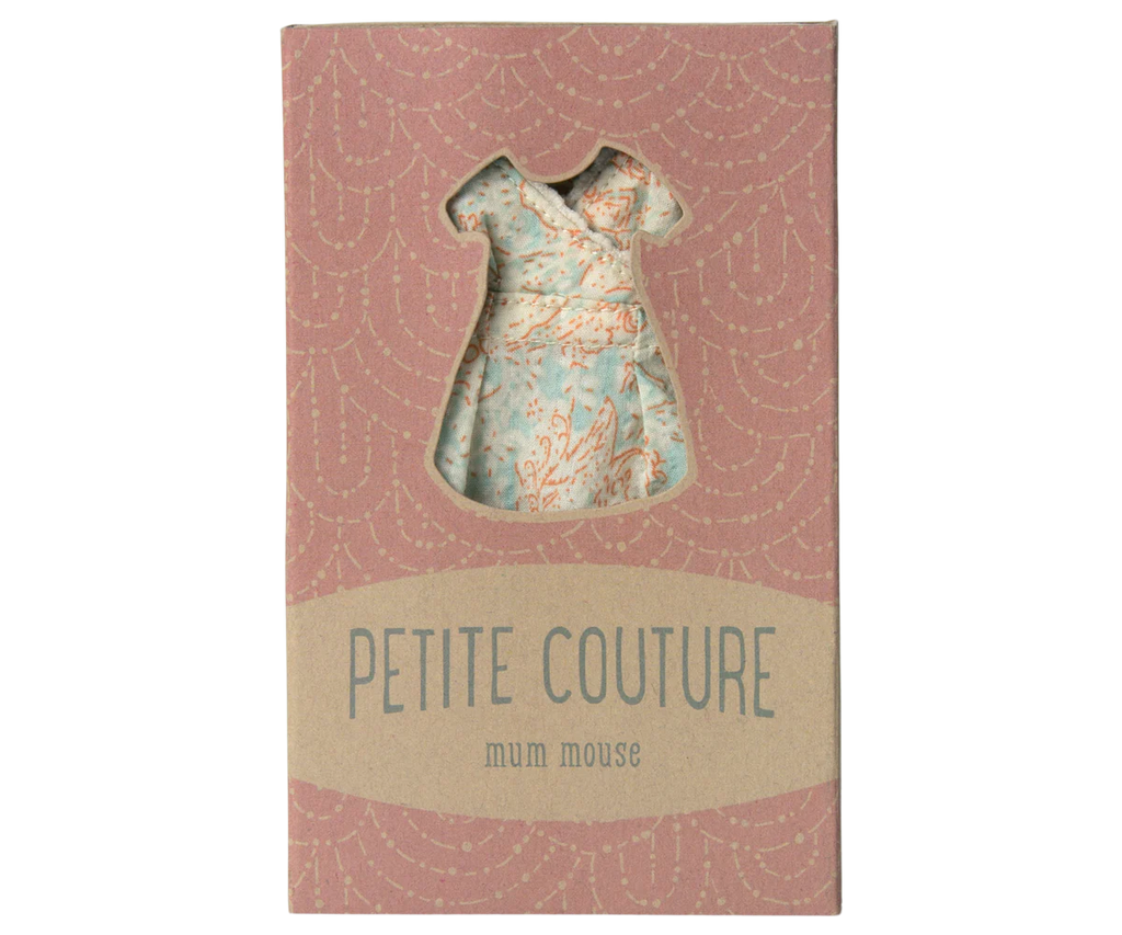 The Maileg Dress For Mum Mouse, shipping in one week, features a stylish pink floral-patterned dress visible through a dress-shaped window. The packaging, with its pink backdrop and subtle wave pattern, adds a touch of charm to this fashionable ensemble.