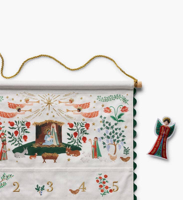 A Nativity Embroidered Hanging Advent Calendar featuring embroidered nativity scenes and numbering, displayed alongside a matching angel ornament.