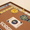 A 3-in-1 Game Collection featuring Monopoly, Sorry & Mancala is shown with yellow and blue pawns on the Sorry! board and a number 1 card near "HOME," set on a brown background—ideal for classic game enthusiasts' cabinets.