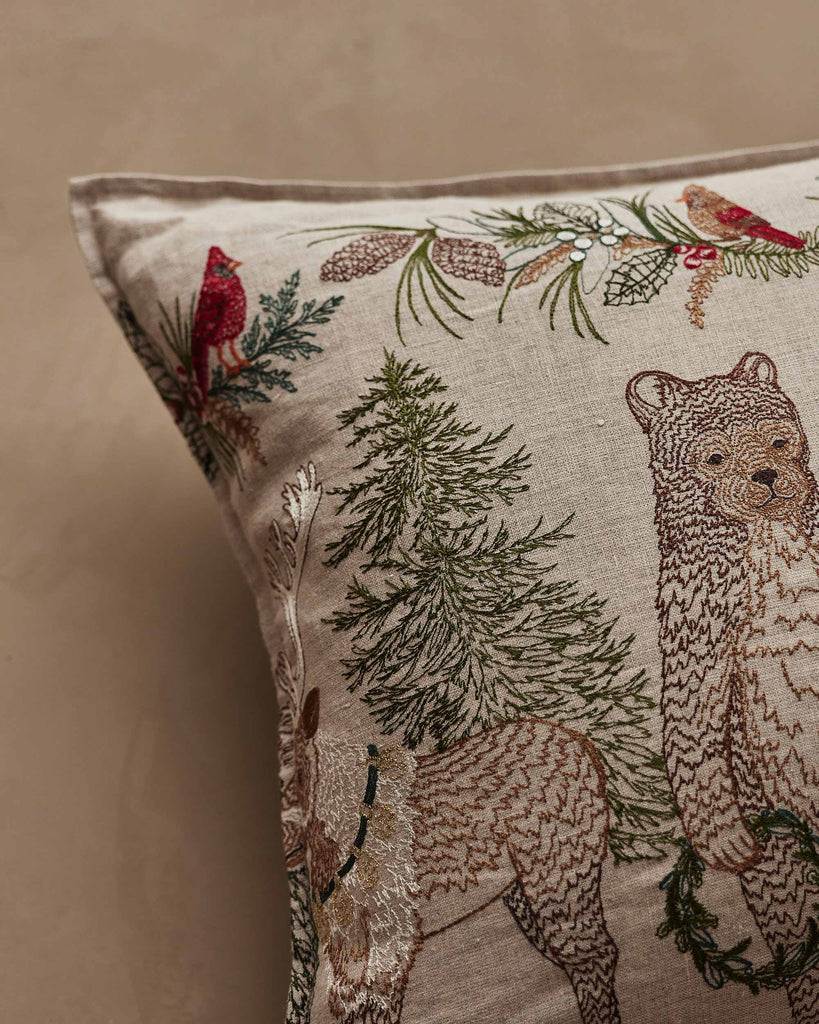 Coral & Tusk Christmas Cheer Lumbar Pillow featuring embroidered woodland animals, evergreen trees, and festive greenery for woodland Christmas decor.
