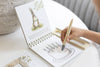 A child uses a water pen to color a cake illustration of Rabbit in a Winnie-the-Pooh: Pooh’s Birthday Surprise (Water Reveal) book.