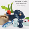 Pots & Pans Kitchen Accessories set featuring a navy pot with a lid, salt and pepper shakers, and wooden play food, with text reading “MIXING PLAY WITH EARLY LEARNING” and “Play Foods Sold Separately.”
