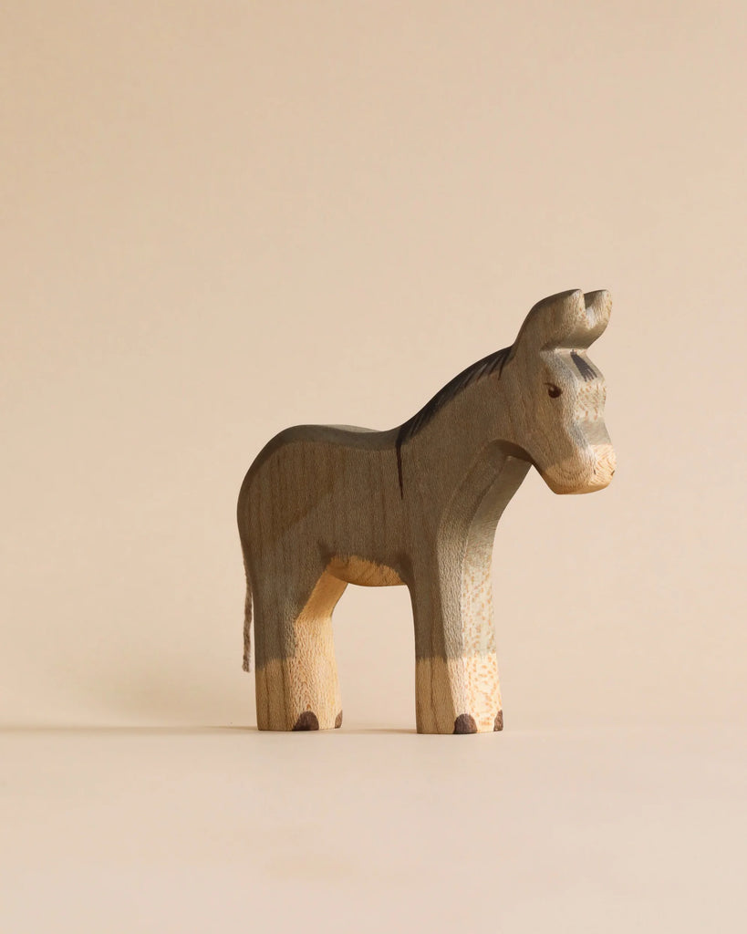 A minimalist, sustainable Handmade Holzwald Donkey toy with a grey body and lighter natural wood legs.