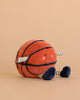The Mon Ami Sports Ball Set features a smiling basketball plush toy with striped arms and legs, navy blue feet, and a light brown background.