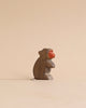 Small wooden baboon figurine from the Handmade Holzwald Safari Animals Set, featuring a painted red face.