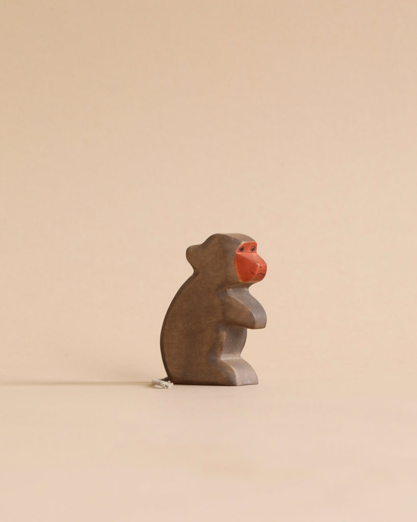 Small wooden baboon figurine from the Handmade Holzwald Safari Animals Set, featuring a painted red face.