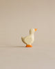 A simple Handmade Holzwald Gosling figurine standing against a neutral beige background. The high-quality duck is painted white with orange feet and a hint of orange on its beak.