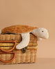 The Senger Naturwelt Cuddly Animal - Turtle, featuring a brown shell and cream limbs, rests on a wicker basket with its organic cotton grain pillow for added comfort against a beige background.