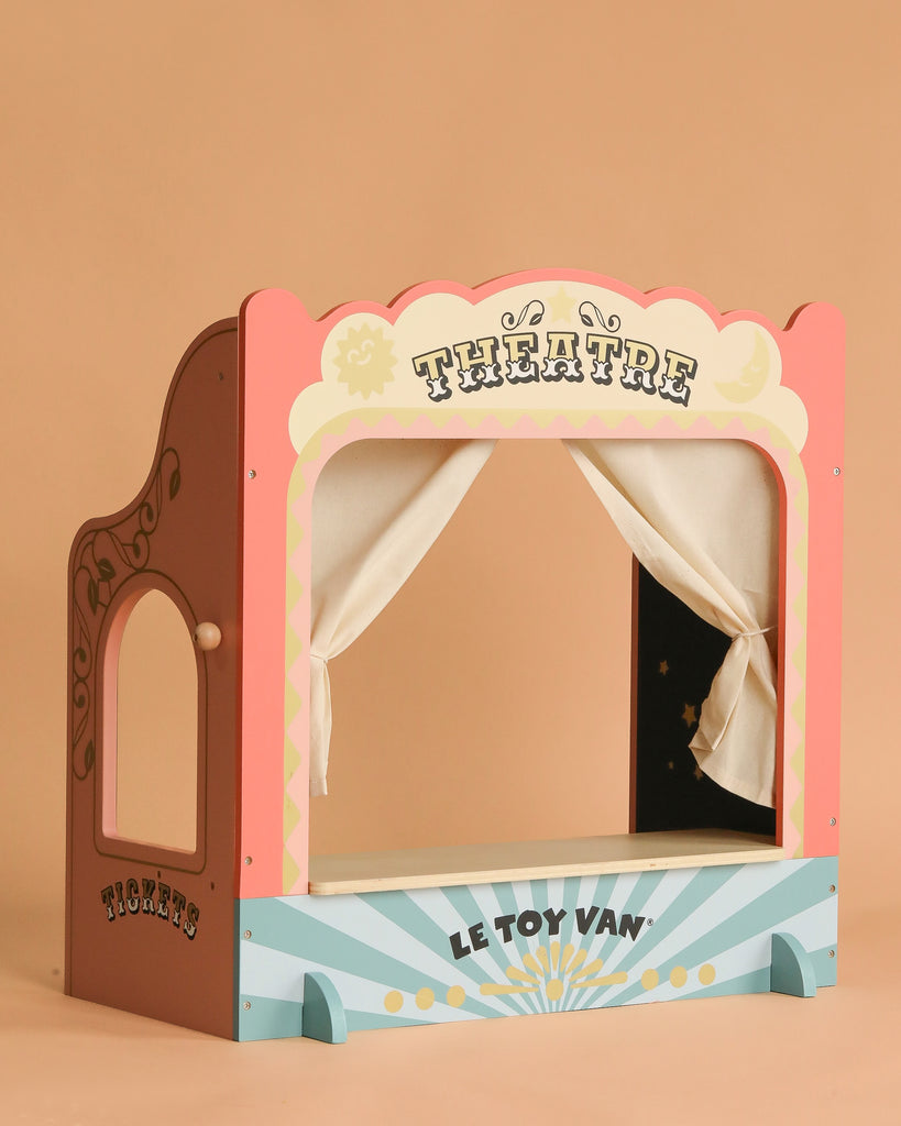 The Tabletop Puppet Wooden Theater is a charming wooden play theater with pastel colors, "THEATRE" at the top, "LE TOY VAN" below, and a side "TICKETS" sign on a light brown background—perfect for imaginative play.