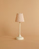 The Maileg Cozy Green Room Set includes a small white table lamp with a pink polka-dot lampshade—ideal as Maileg mouse furniture or as a charming miniature accessory.