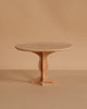 The Maileg Oval Dining Table, Miniature - Bunny/Rabbit Size features a small, round wooden design with a single pedestal base, highlighting fine craftsmanship against a plain beige background.