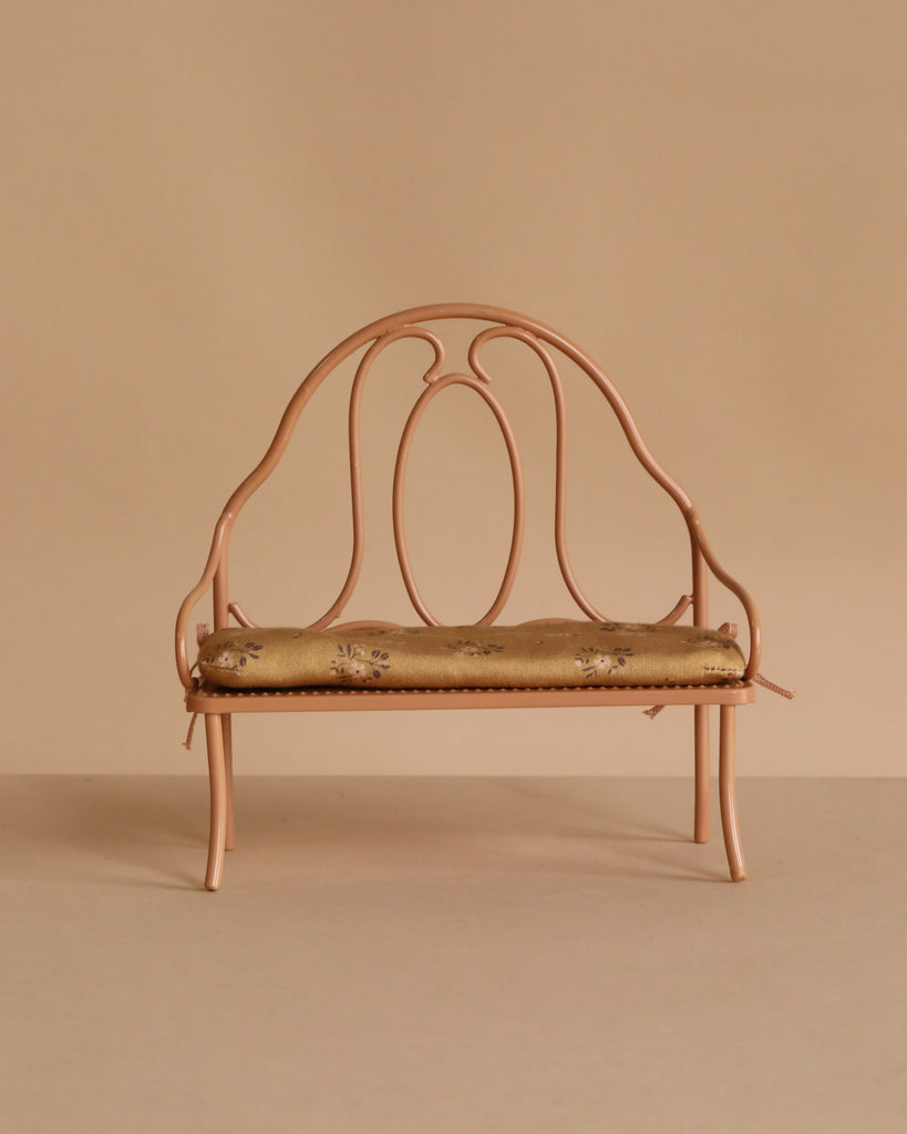 Small Maileg Medium Mouse Set vintage metal bench with a curved backrest and a floral patterned cushion.