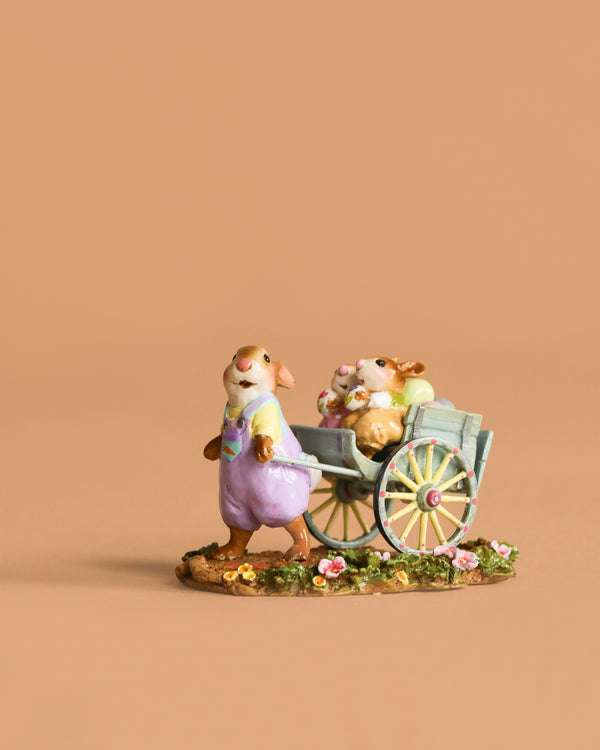 The Wee Forest Folk Tiny Collectible - Easter's on its Way features a hand-sculpted mouse in overalls pulling a cart with two baby mice on a flower-adorned base, perfect for collectors. Not a toy.