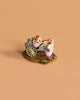 The Wee Forest Folk Tiny Collectible - Easter's on its Way features a rabbit in purple overalls pulling a cart of pastel eggs and another bunny, set on a textured green and yellow base.