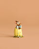 The Wee Forest Folk Tiny Collectible - Bluebird of Happiness features a small, hand-sculpted rabbit figurine in a yellow dress with painted flowers and a flower crown, standing on a matching base.
