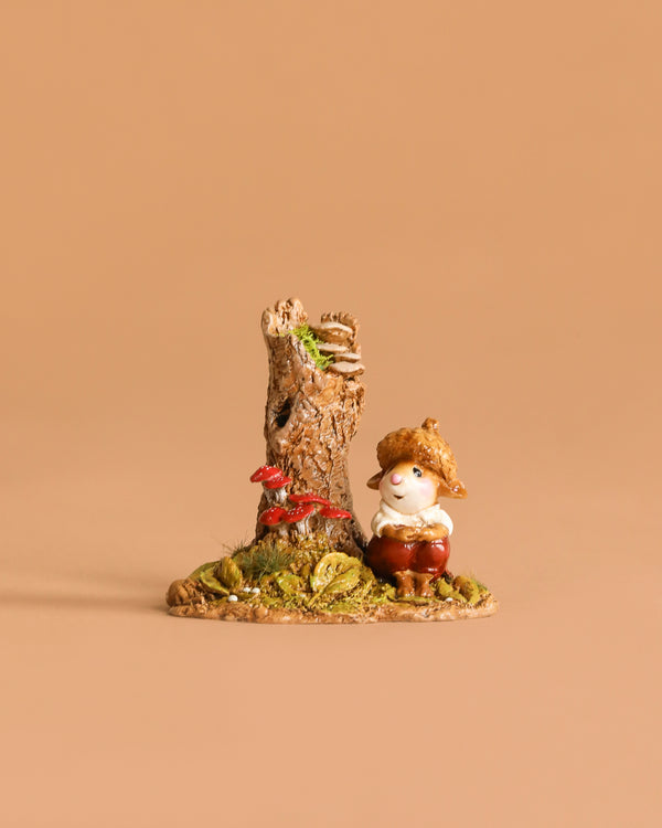Wee Forest Folk Tiny Collectible - My Happy Place: A small, hand-sculpted gnome with a straw hat sits by a tree stump and red mushrooms on grass, set against a beige background.