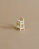 A small, white Maileg Mouse Size High Chair on a plain beige background, showcasing a minimalist design and simple construction.