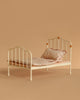 A Maileg Bedroom Set with Grandma & Grandpa, featuring a small cream-colored vintage bed adorned with a pink patterned pillow and blanket, is set against a beige background.