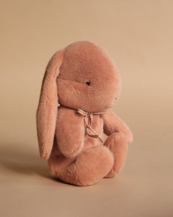 The Maileg Plush Bunny, Medium - Vintage Rose, is a soft light brown stuffed animal with long floppy ears and a simple ribbon around its neck, sitting upright against a plain beige background.