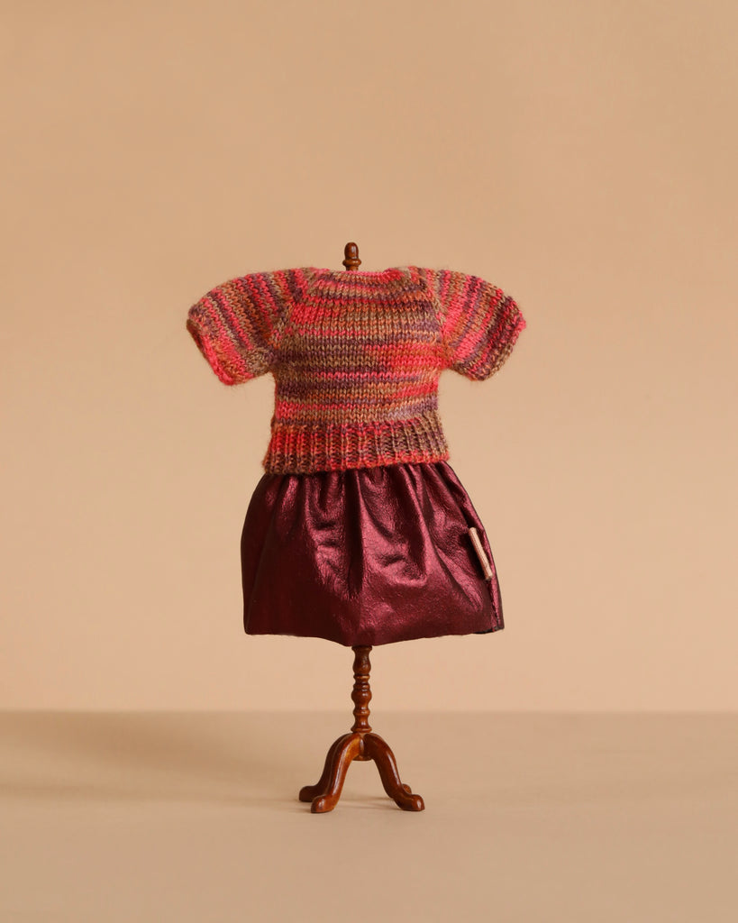 A Maileg Mum Mouse mannequin models the Extra Clothing set—featuring a multicolored knitted blouse and shiny burgundy skirt—against a plain beige background.