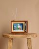The Christmas Music TV - Yeti and Rudolf features a vintage light-up TV with antennas on a wooden table, showcasing snowy trees, a snowman, and Rudolf on the screen—an ideal holiday decoration against a plain beige background.