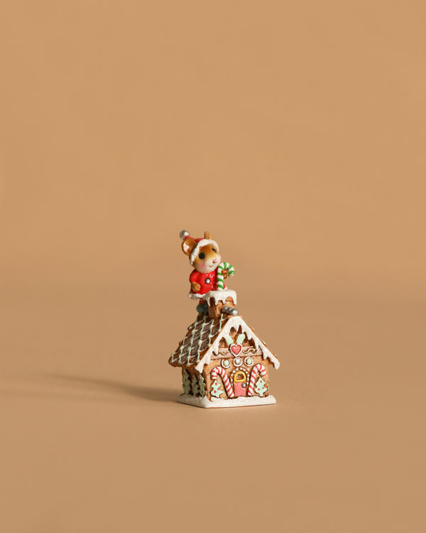 The Wee Forest Folk Tiny Collectible - Santa's Gingerbread House features a hand-sculpted mouse in a red outfit atop a snow-covered gingerbread house—an adorable piece for miniature collections.