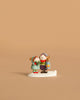 The Wee Forest Folk Tiny Collectible - The Little Wanderers features two children in winter clothes, one holding a lantern, standing together on a white base.