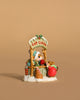 The Wee Forest Folk Tiny Collectible - Hot Cocoa Comin' Up! (Not a Toy) features two hand-sculpted mice at a snowy cocoa stand, surrounded by candy canes, gifts, and holiday decor—one serving cocoa and one in a red coat sipping.