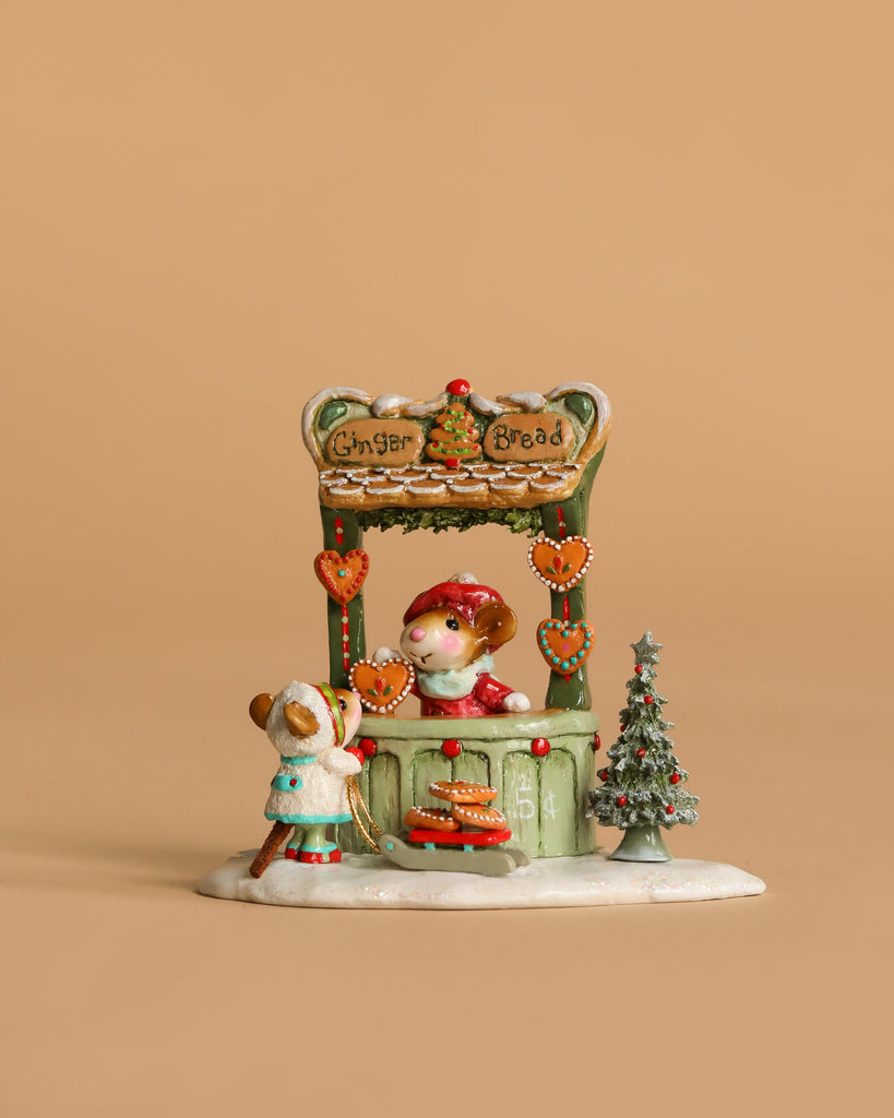 A Wee Forest Folk Tiny Collectible – A Gingerbread Christmas features two hand-sculpted mice at a gingerbread stand with hearts, Christmas treats, and a small tree, set against a beige background.