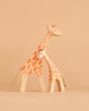 Two stylized Ostheimer Giraffe - Standing figurines, one large and one small, stand closely together against a solid beige background, evoking the charm of handcrafted wooden toys and inspiring imaginative play.