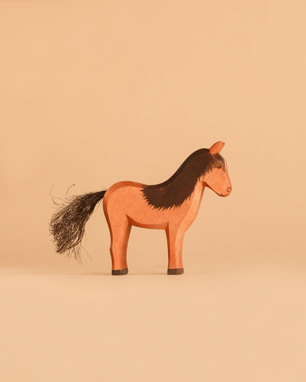 The Ostheimer Horse - Iceland Hrokur, a handcrafted wooden toy horse featuring a painted brown body with a black mane and tail, stands on a beige background, exemplifying the charm of sustainably sourced Ostheimer toys.